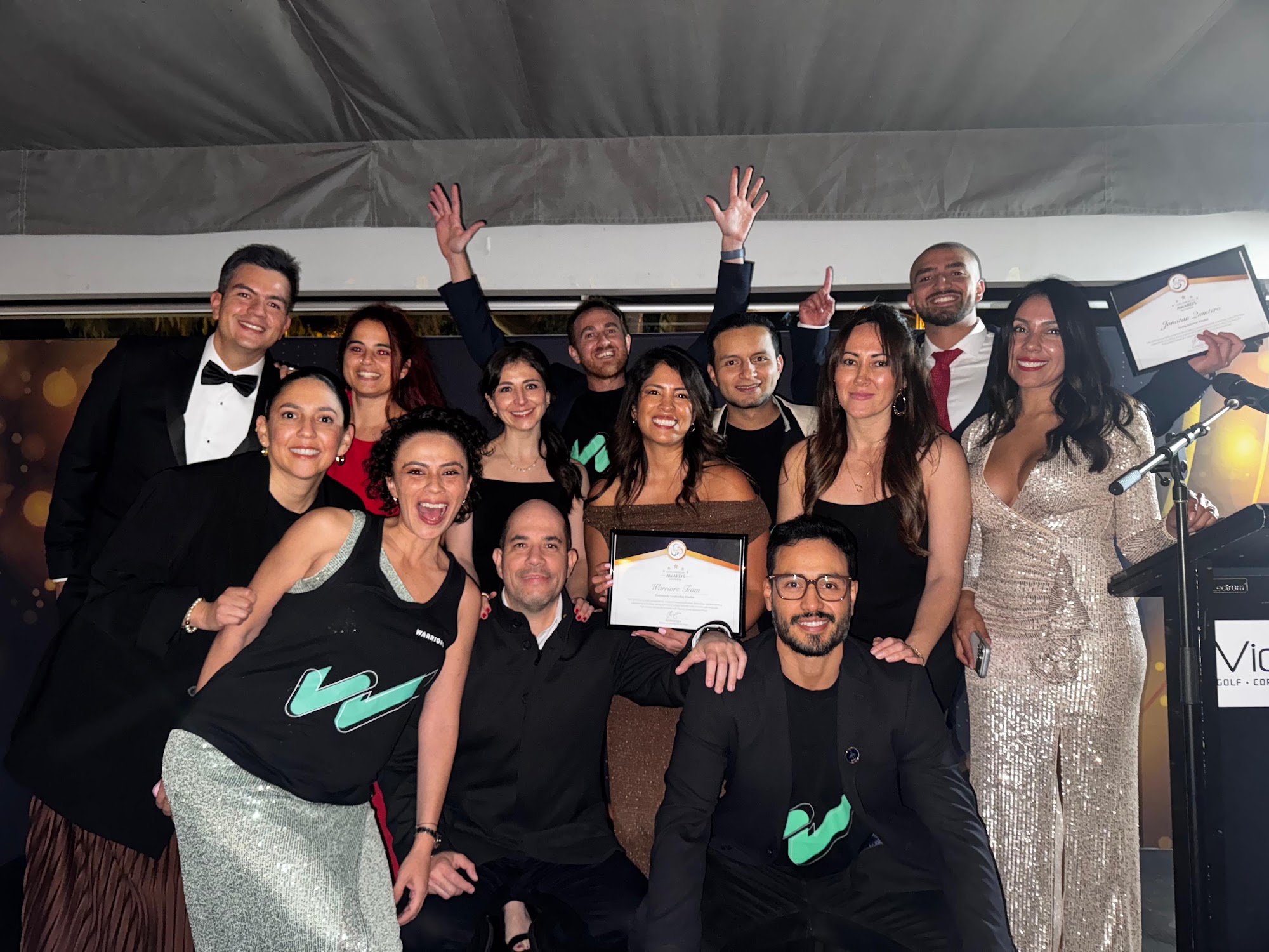Warriors Team Brisbane group on stage at the Latin American Awards Australia gala, holding their finalist certificate